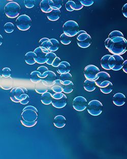 Close-up of bubbles against blue water