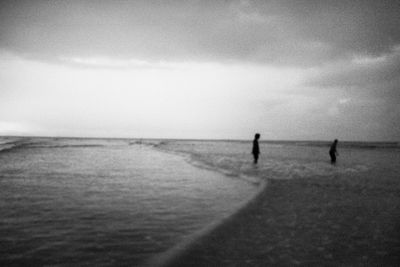 People on beach against sky