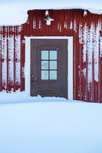 Snow covered house against window of building