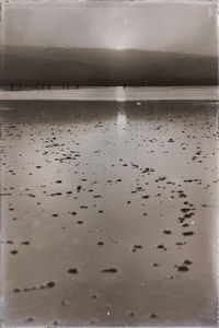 Wet sand on beach against sky