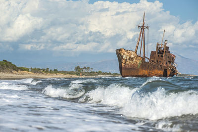 Sailboat on sea shore against sky