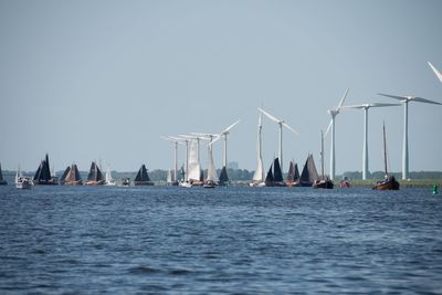 Sailboats in sea against clear sky