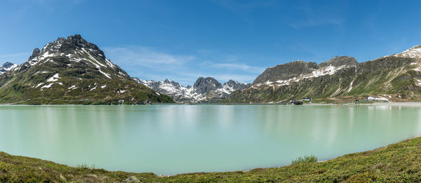 Scenic view of lake and mountains against blue sky