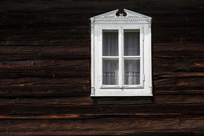 Carved window of a traditional log cabin in orava region.