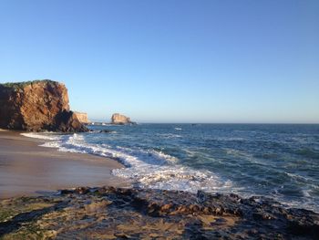 Scenic view of sea against clear blue sky