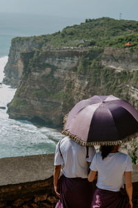 Rear view of woman holding umbrella