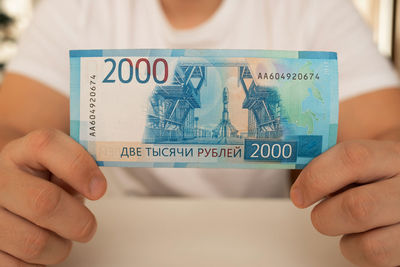 A close-up man holds in his hands an unfolded bill with a face value of 2000 rubles. russian money.