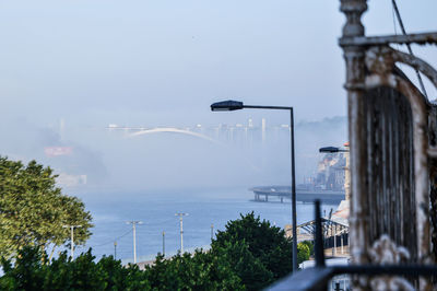 Bridge over river in city against sky