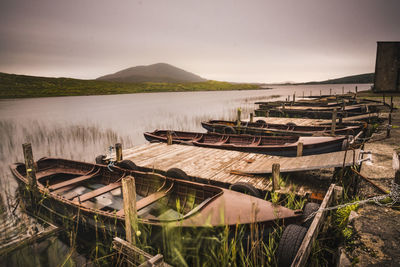 Abandoned boats in lake against sky