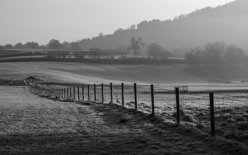 Wooden fence on field against sky