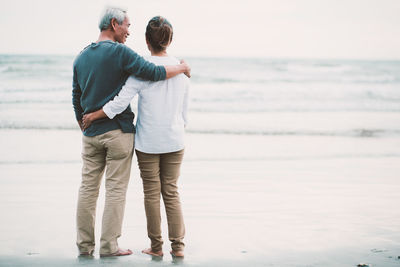 Rear view of couple standing on beach