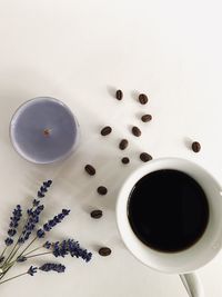 Coffee cup, lavender flowers, candle and coffee beans on white background