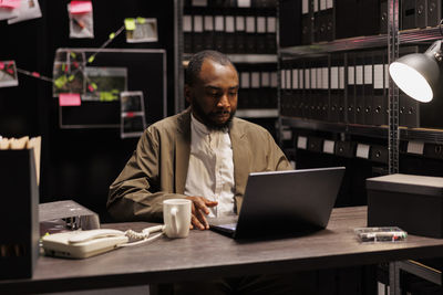 Portrait of young man using laptop at table