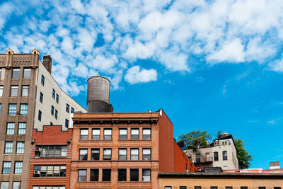 Low angle view of buildings against cloudy sky