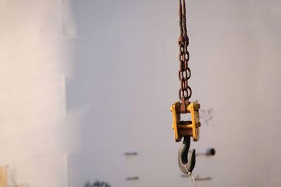 Close-up of chain hanging against wall
