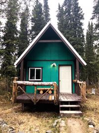 Abandoned house by trees in forest