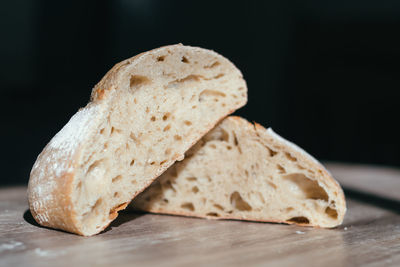 Close-up of bread on table against black background