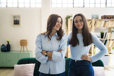 Portrait of friends standing against wall