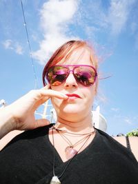 Close-up of girl wearing sunglasses against sky