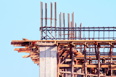 Low angle view of construction site against clear blue sky