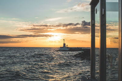 Boat sailing in sea against sky during sunset