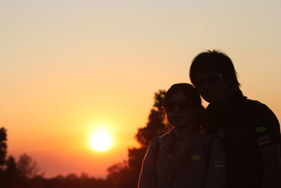 Silhouette couple against clear sky during sunset