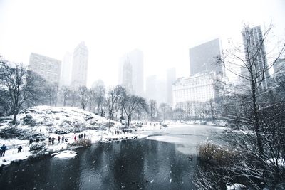 Snow covered cityscape against sky during winter