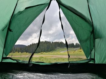 Scenic view of landscape seen through tent against sky