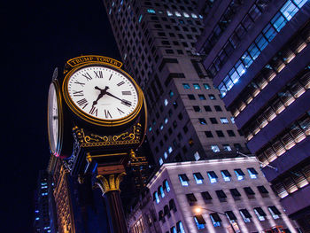 Low angle view of illuminated clock tower at night