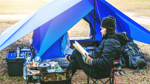 Man sitting on chair at campsite