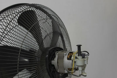 Low angle view of electric fan against wall