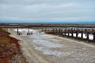 Pier on beach against sky