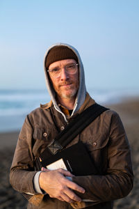 Portrait of mature man looking at camera standing on beach