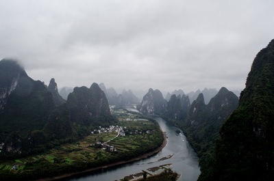 Scenic view of mountain road against cloudy sky