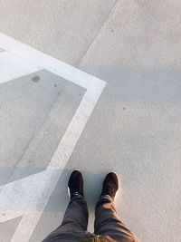 Low section of man standing on road