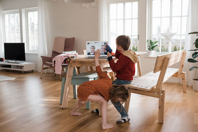 Kids showing their grandparents their toys via video call in isolation