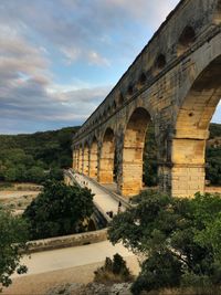 Arch bridge against cloudy sky