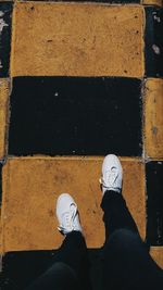 Low section of man standing on tiled floor