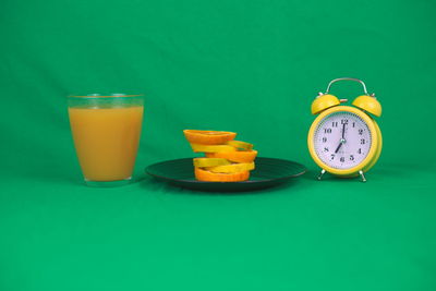 Glasses on table against green background