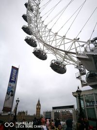 Low angle view of chain swing ride against sky