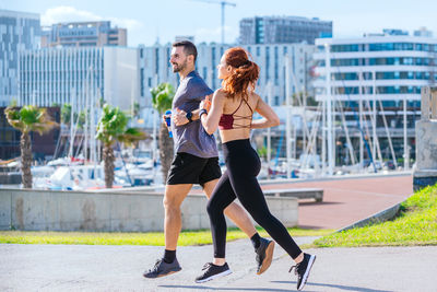 Full length of young woman exercising in city
