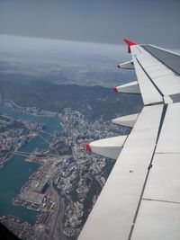 Airplane flying over cityscape against sky