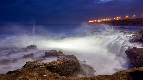 Scenic view of waterfall against sky