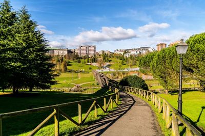 View of footpath in city against sky