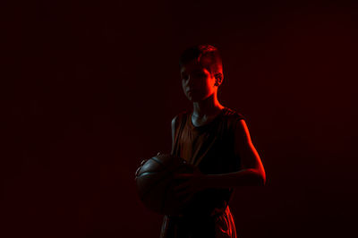 Full length of boy standing against black background