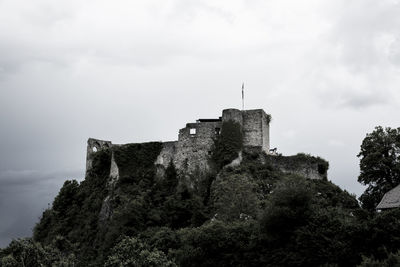 Low angle view of castle on hill against cloudy sky