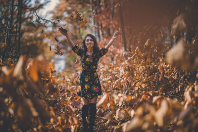 Woman standing with arms outstretched in the background