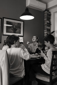 Rear view of people sitting on table