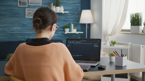 Side view of man using laptop at home