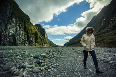 Full length of woman walking on rock against sky